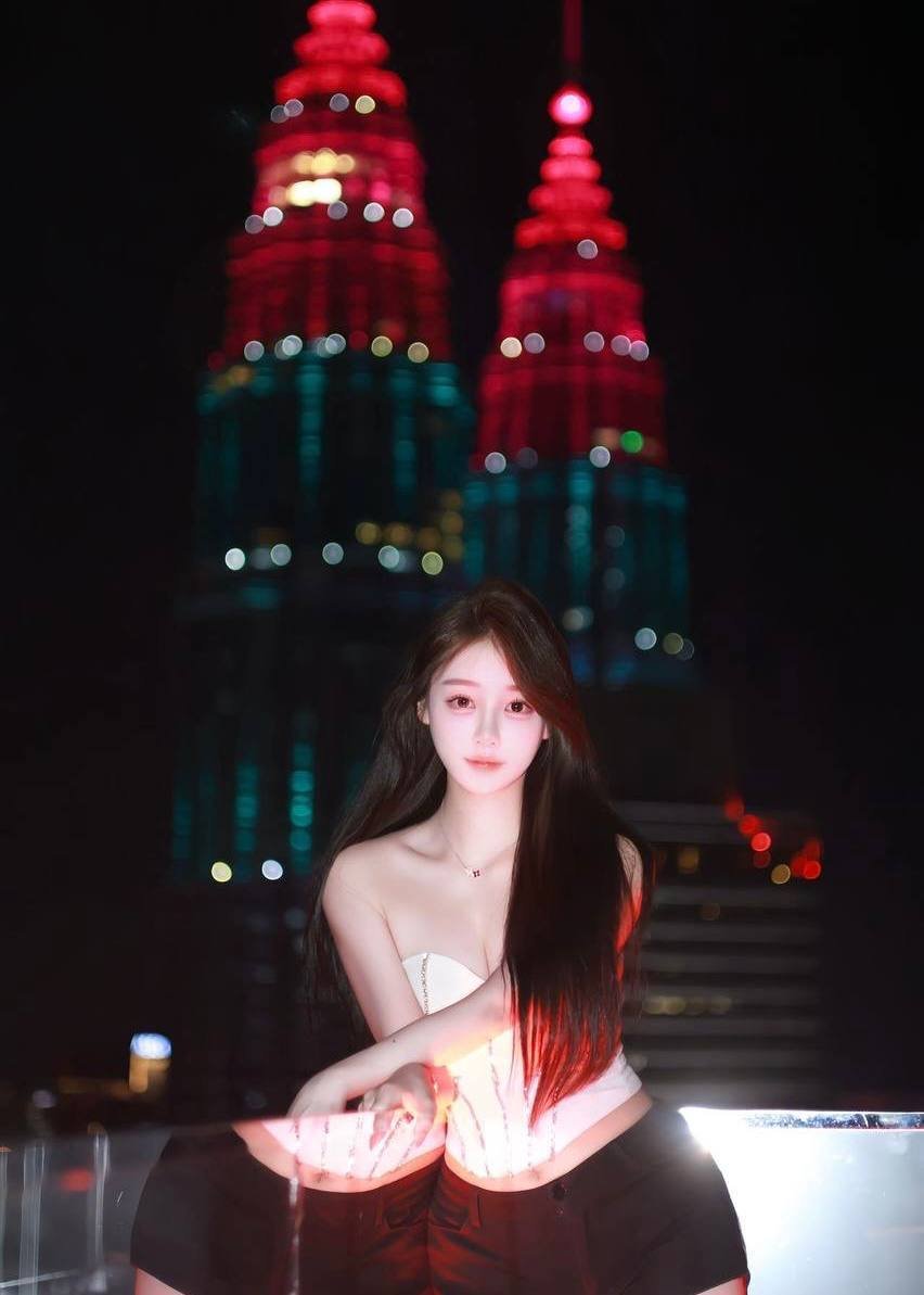 Xiaoling – Elegant Chinese model enjoying Kuala Lumpur nightlife with Petronas Towers in background.